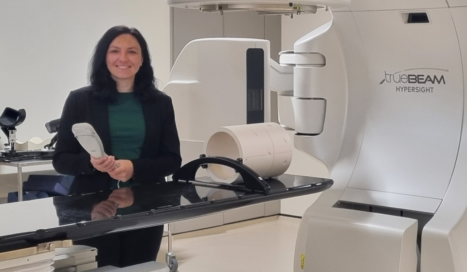 A woman in a clinical science lab with a large white machine
