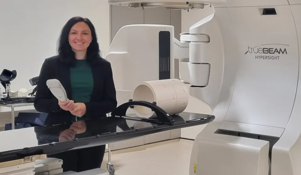 A woman in a clinical science lab with a large white machine