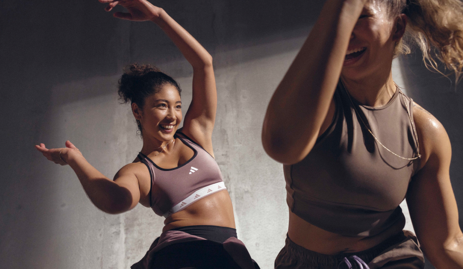 Two women in workout crop tops moving to music