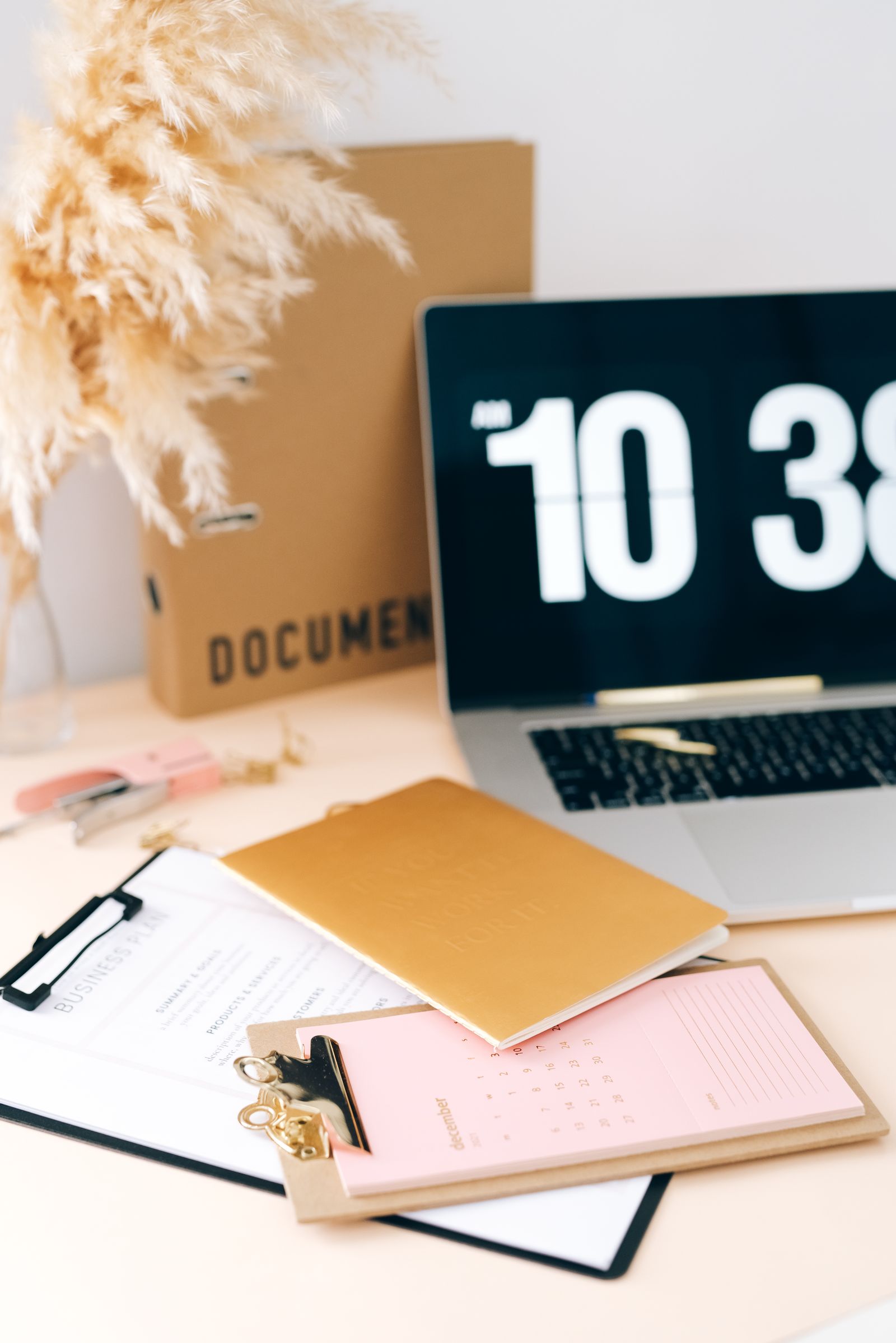 A tidy desk with clipboards, folders and a laptop set out for a handover before parental leave