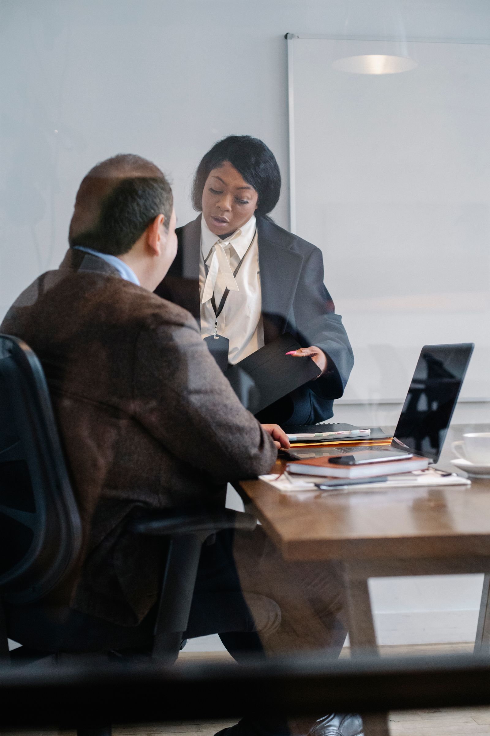 A partner reviewing a printed report with a finance adviser in a meeting room