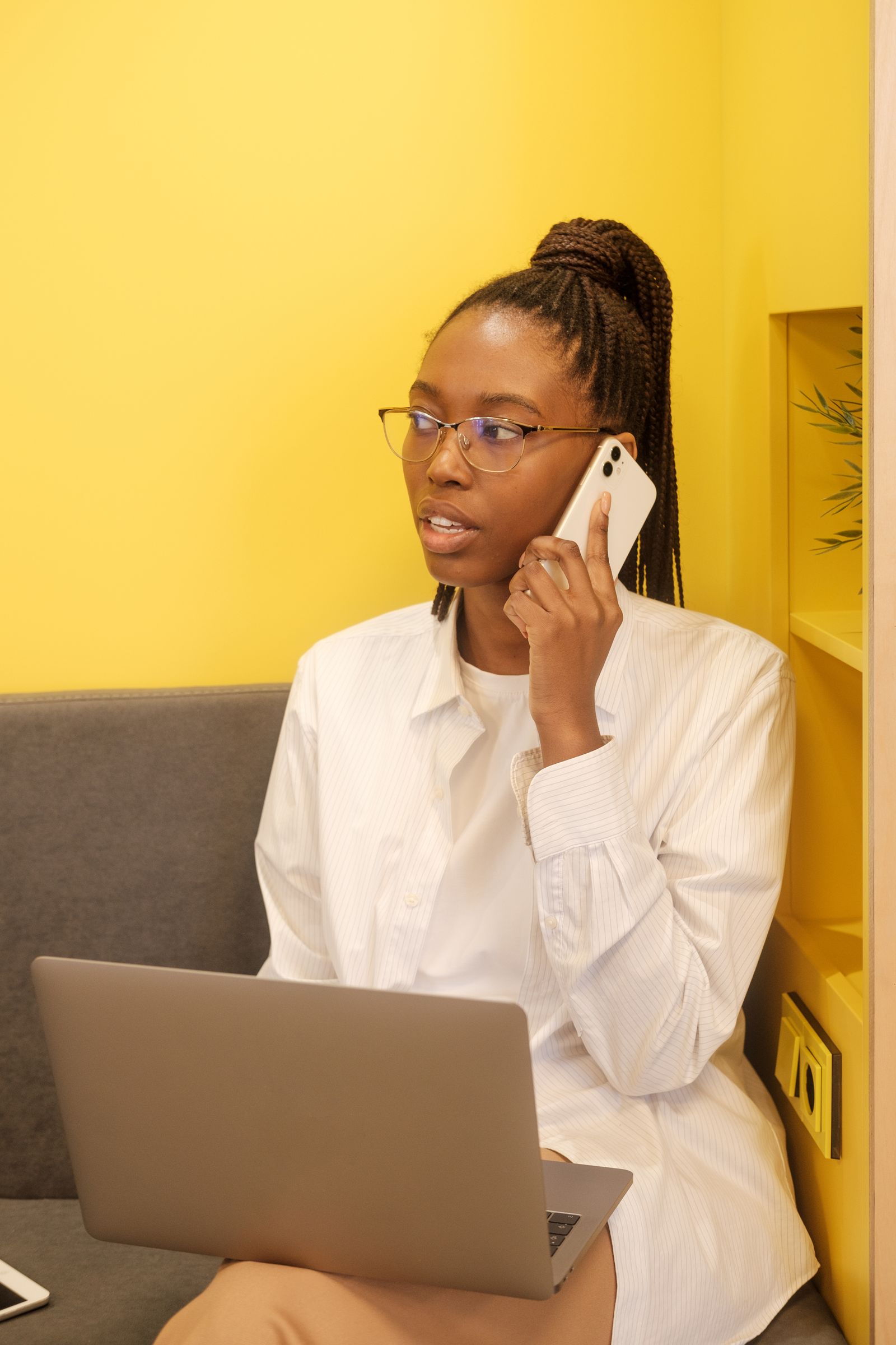 An office manager taking a phone call while working on a laptop