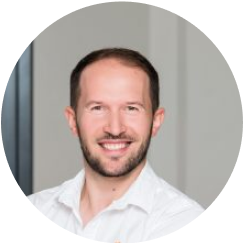 A man in a white shirt is smiling.