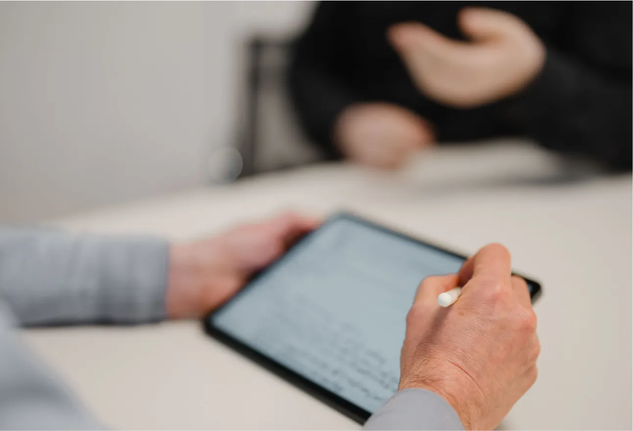 A person sitting at a table with a tablet.