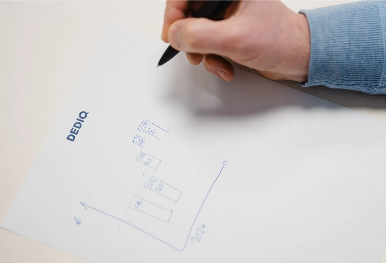 A person writing on a piece of paper with a pen.
