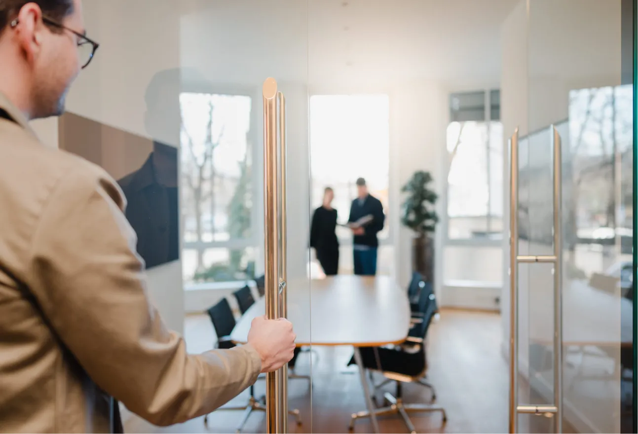 A man standing in front of a glass door.