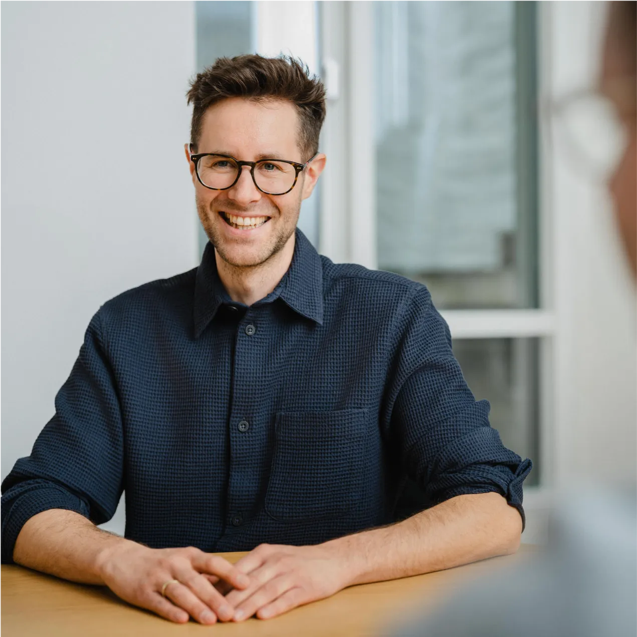 A man sitting at a table with a smile on his face.