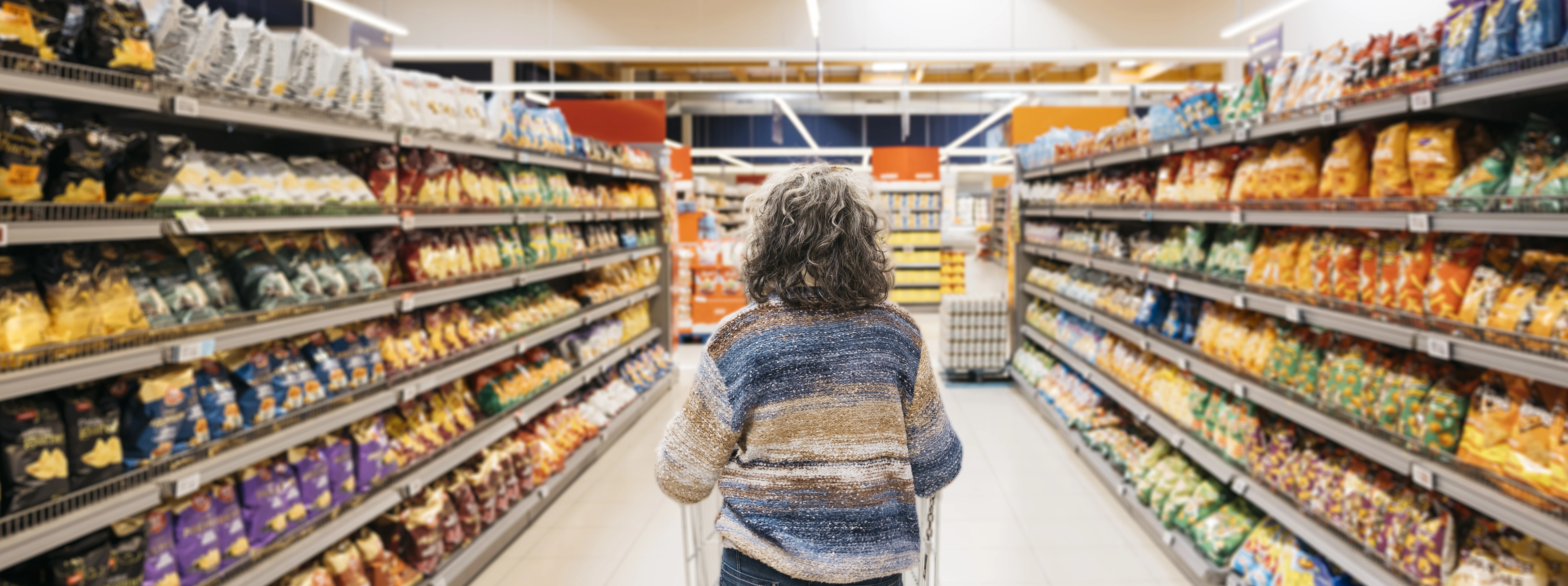 woman-making-choices-in-supermarket-snack-aisle