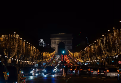 Vue nocturne des Champs-Élysées illuminés de guirlandes dorées — l’occasion idéale de loger tout près pour profiter des illuminations à pied.