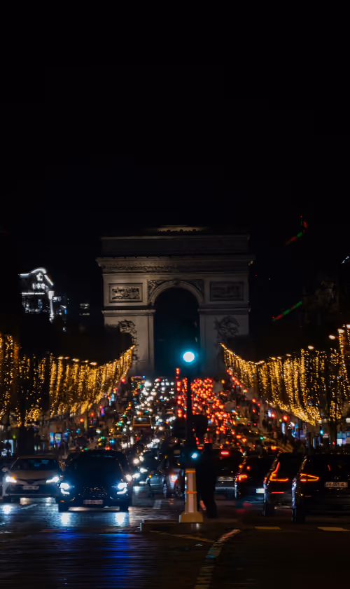Vue nocturne des Champs-Élysées illuminés de guirlandes dorées — l’occasion idéale de loger tout près pour profiter des illuminations à pied.