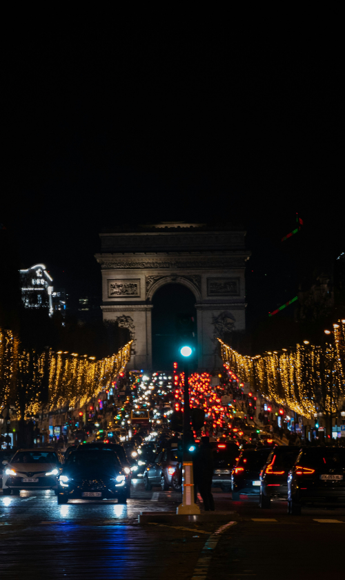 Vue nocturne des Champs-Élysées illuminés de guirlandes dorées — l’occasion idéale de loger tout près pour profiter des illuminations à pied.