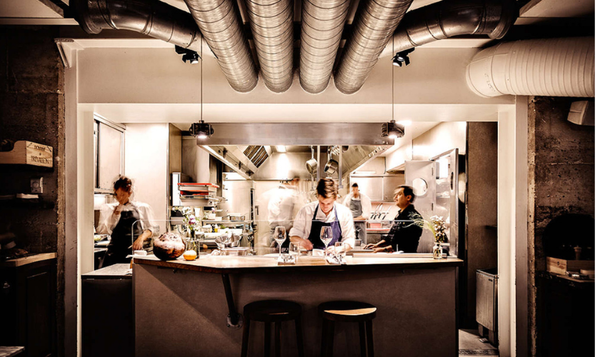 Chef dressant un menu dégustation dans la cuisine d’un restaurant à Paris