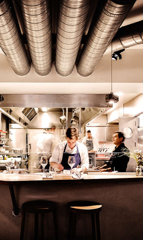 Chef dressant un menu dégustation dans la cuisine d’un restaurant à Paris