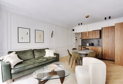 Intérieur contemporain avec espace séjour, coin repas et kitchenette en bois clair dans un appartement design