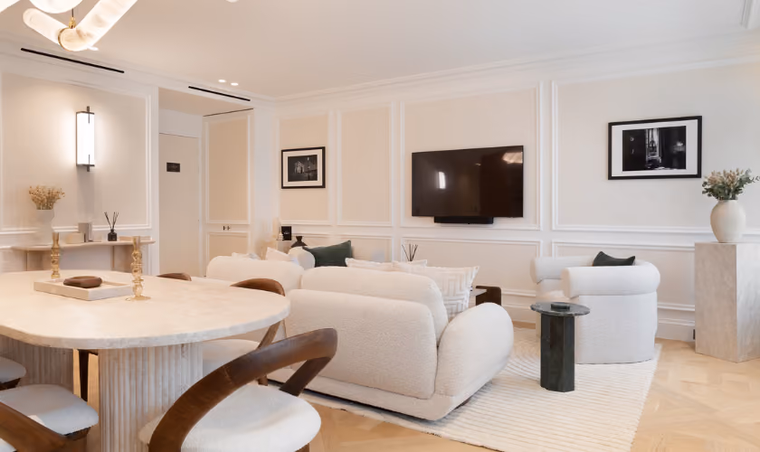 Salon d’hôtel élégant avec canapé, table et télévision murale