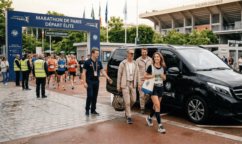 Participants du Marathon de Paris arrivant en zone de départ avec coureurs en arrière-plan