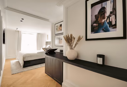 Intérieur élégant montrant une console noire décorée menant vers une chambre.