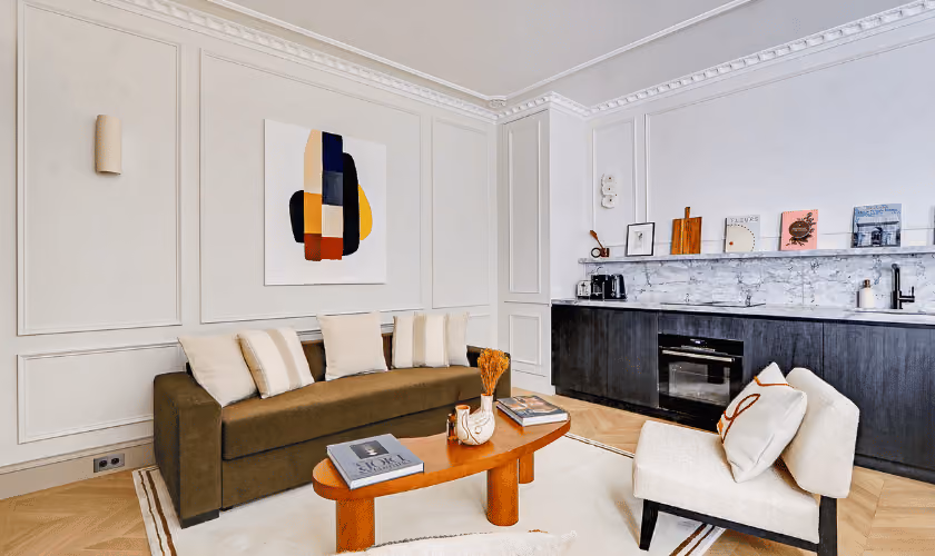 Salon moderne avec canapé marron et cuisine ouverte élégante.