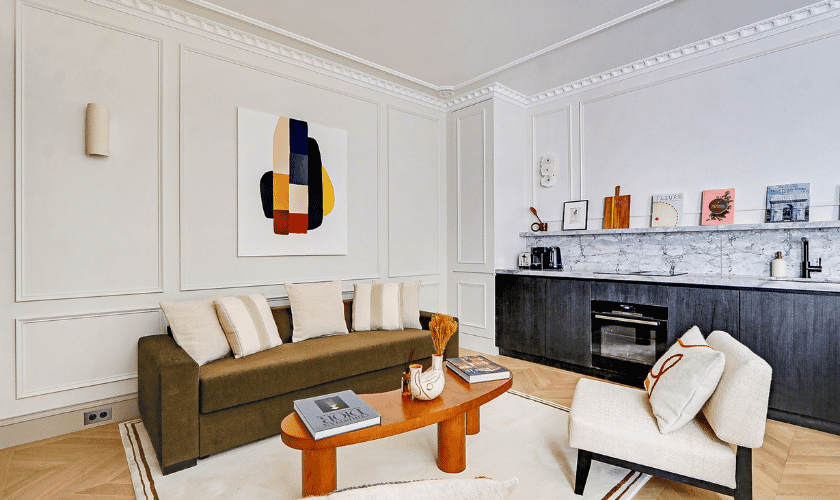 Salon moderne avec canapé marron et cuisine ouverte élégante.