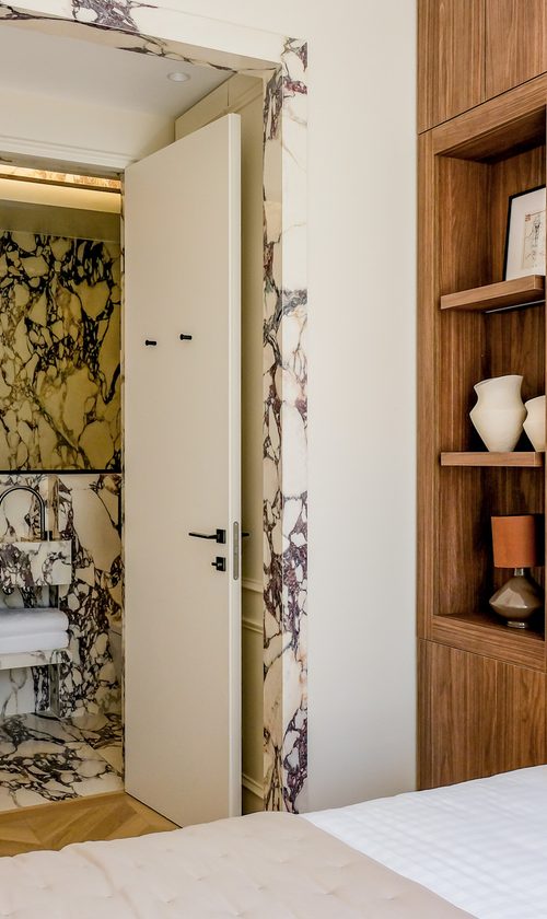 Salle de bain en marbre veiné attenante à une chambre de l'hôtel The Lander