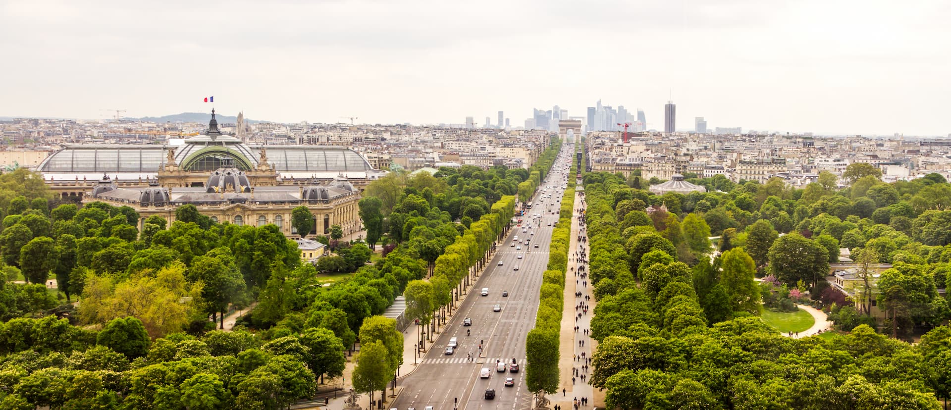 Avenue des Champs-Élysées bordée d'arbres menant à l'Arc de Triomphe, à Paris.