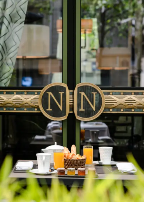 Photo of a table filled with exquisite food on the terrace of Bar 1807 at the Hôtel Napoléon Paris