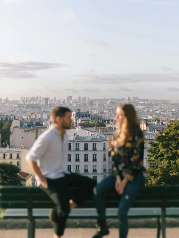 Photo of a couple in front of a panoramic view of the city of Paris