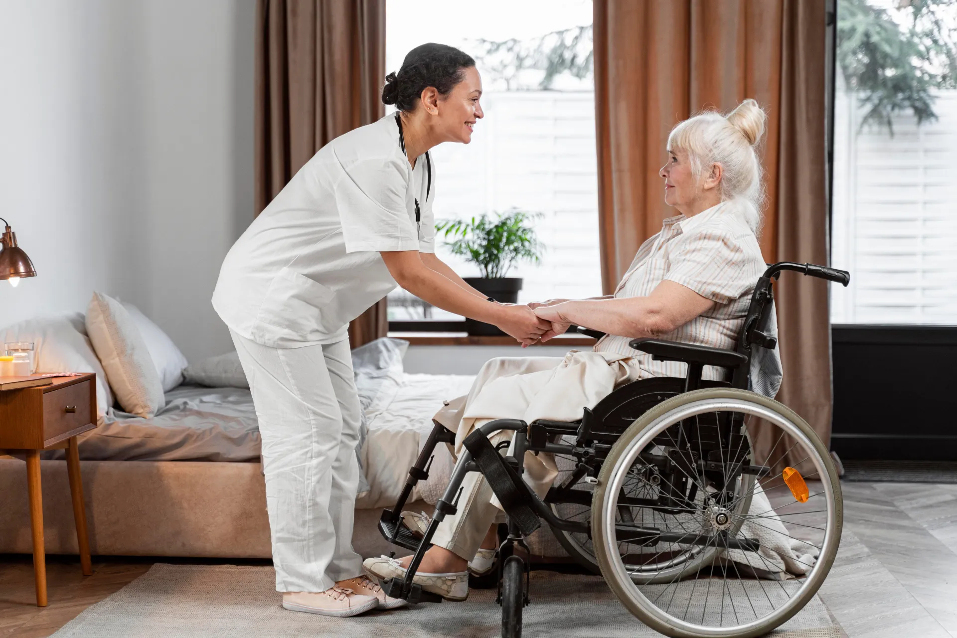 A nurse assists a woman in a wheelchair, providing support and care in a healthcare setting.