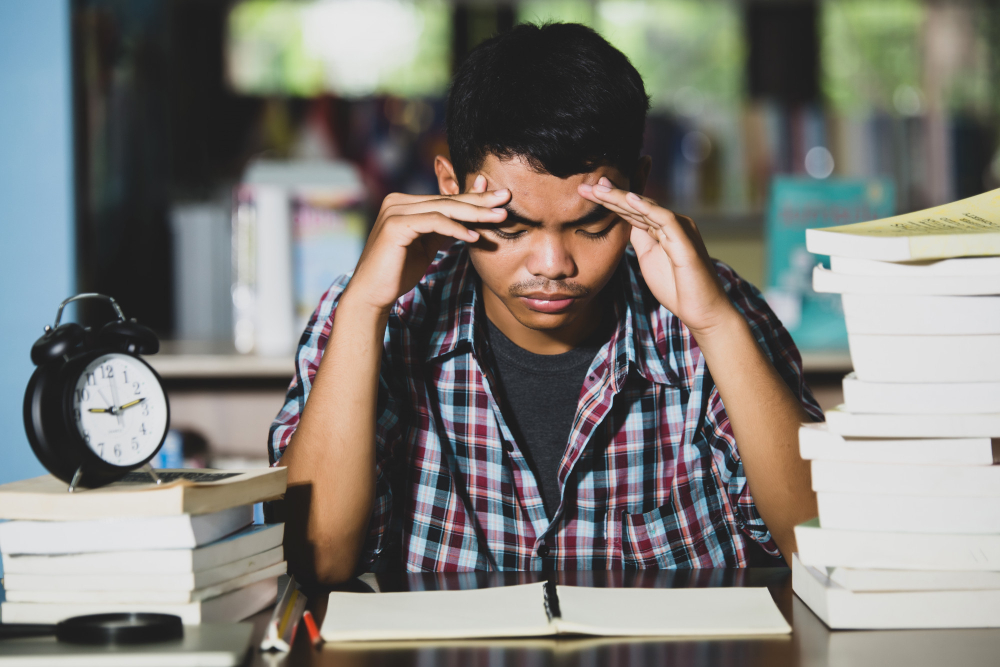 student holding his head - Is History A Level Hard