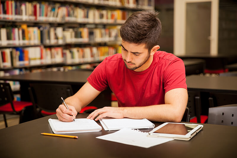 student in a library - How to Revise for Biology GCSE