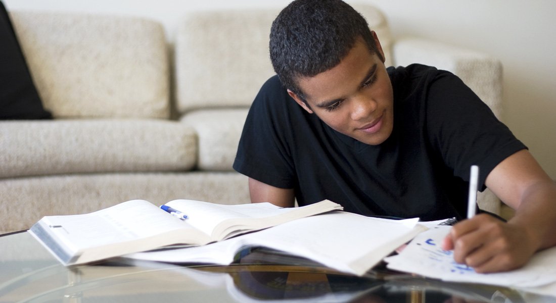 student writing on a book - How to Revise for Biology GCSE
