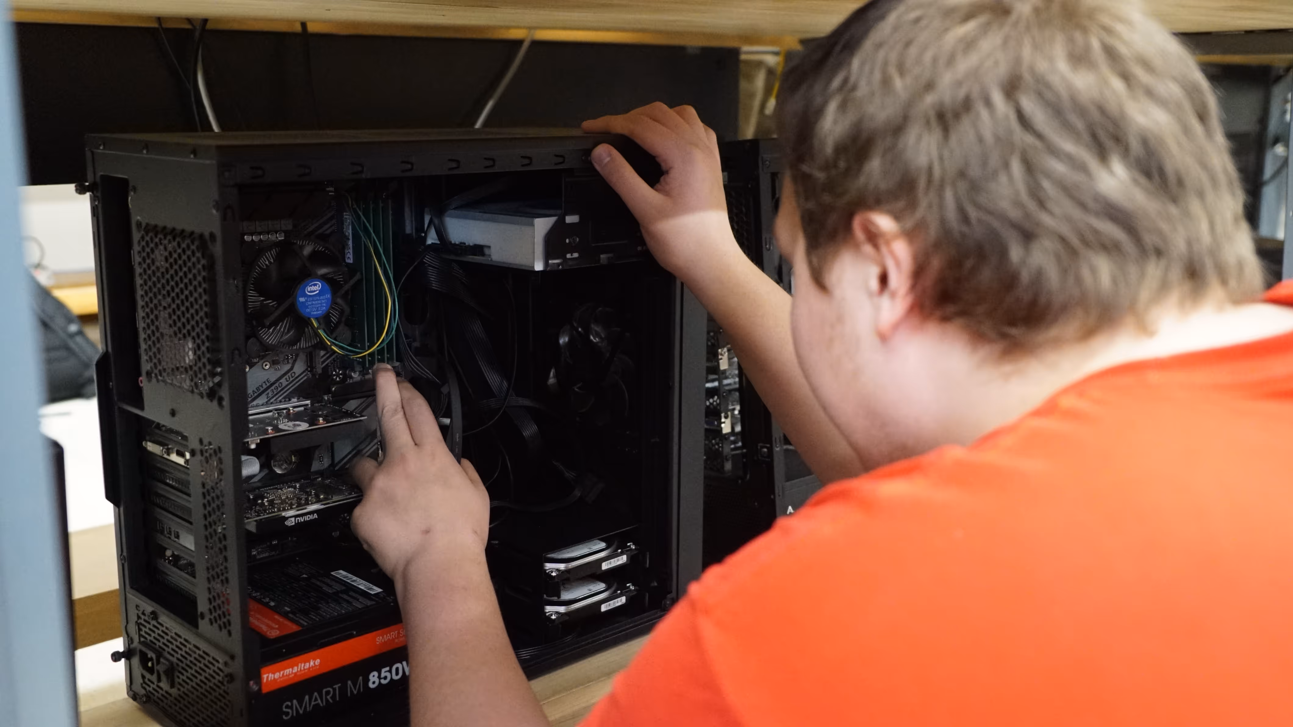 Student taking apart desktop computer