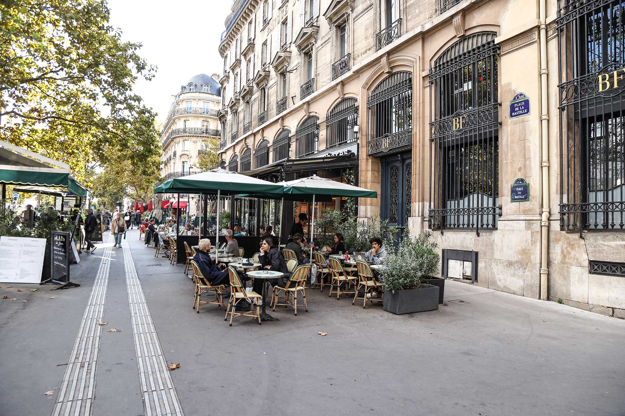 Outside a café along the elegant boulevard beside Place de la Bastille, locals and visitors linger over coffee, conversation, and the simple pleasure of watching life unfold in Paris.