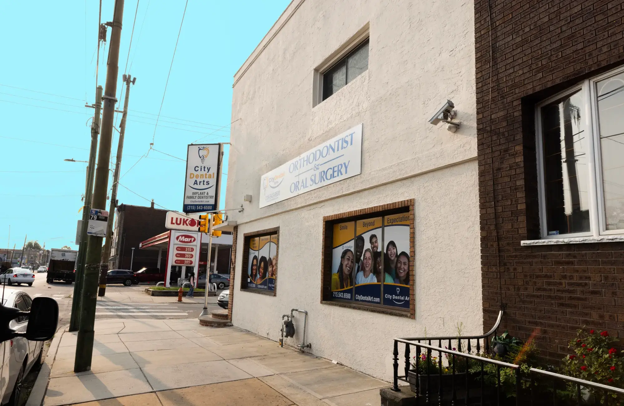 A dental office building with signs for orthodontist and oral surgery services on an urban street.