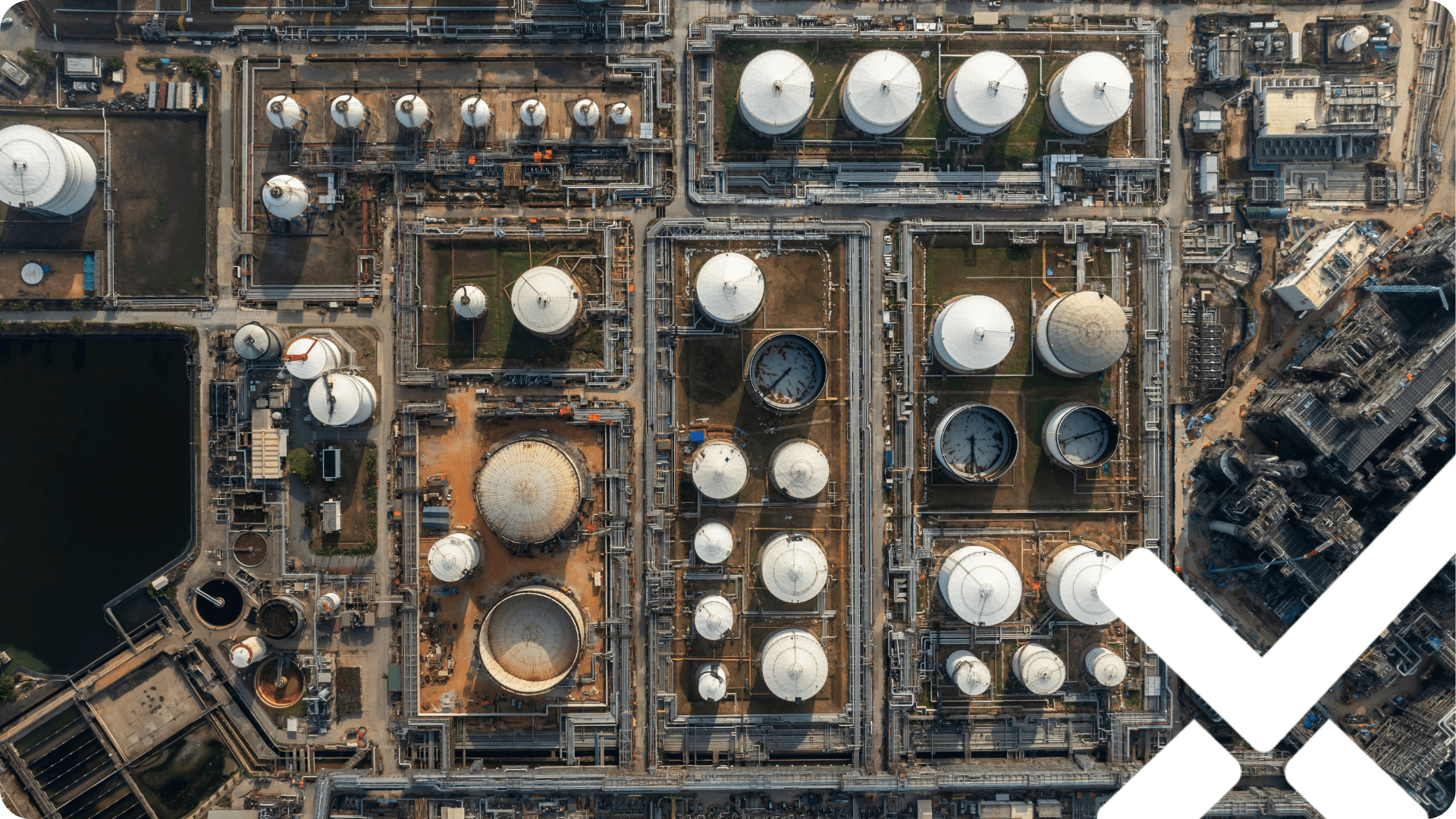 Aerial view of an industrial manufacturing site with storage tanks, illustrating the physical locations where site-level sustainability data originates.