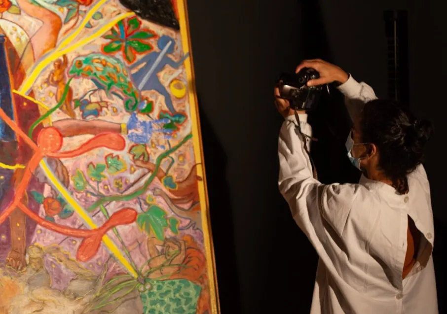 Rapariga em pé, a tirar uma fotografia a um quadro restaurado.
Conservação e Restauro de Bens Culturais.