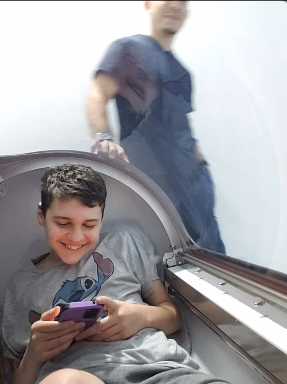 Patient resting in hospital bed with healthcare worker's green-gloved hand nearby