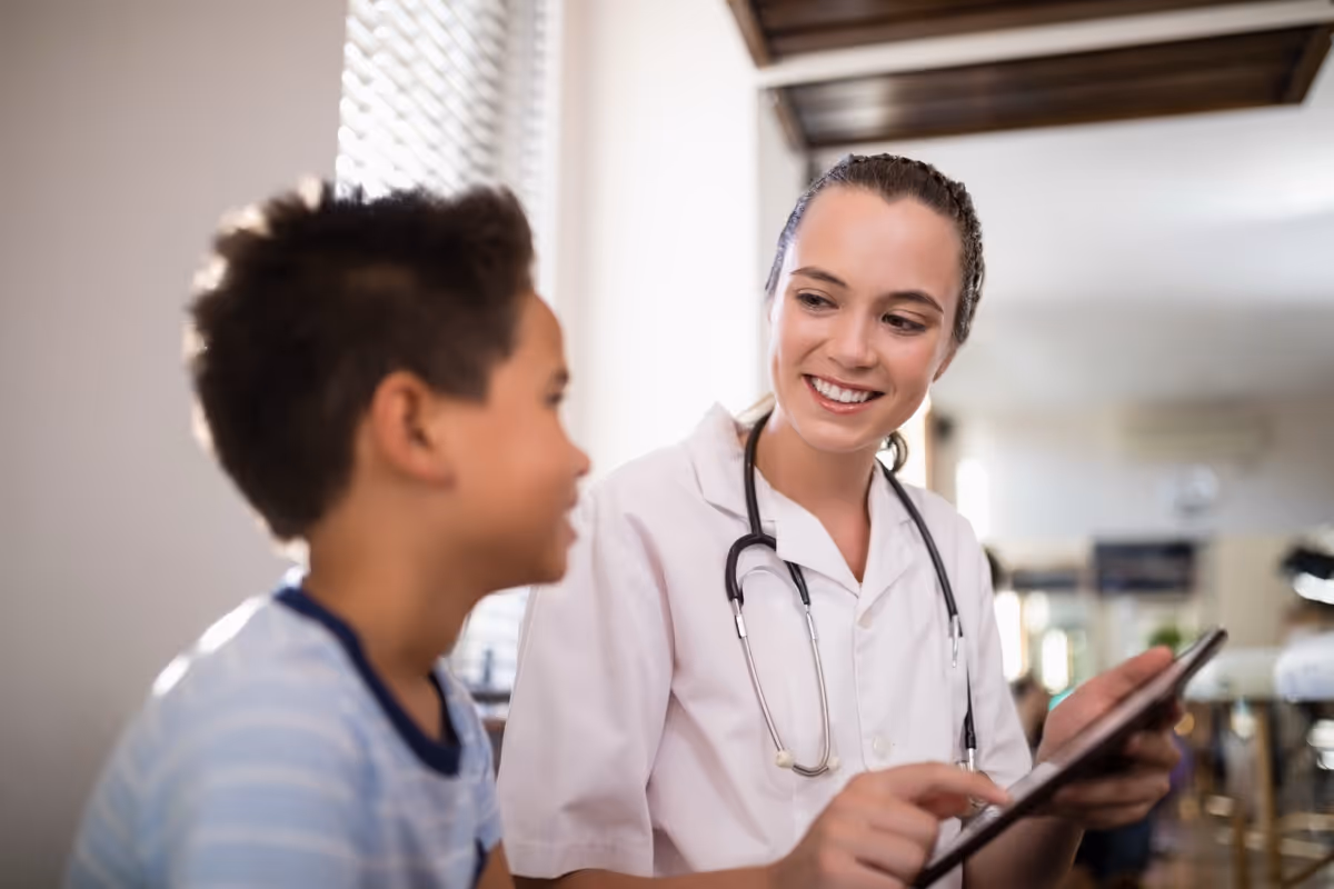 Smiling doctor reviewing medical information with young patient
