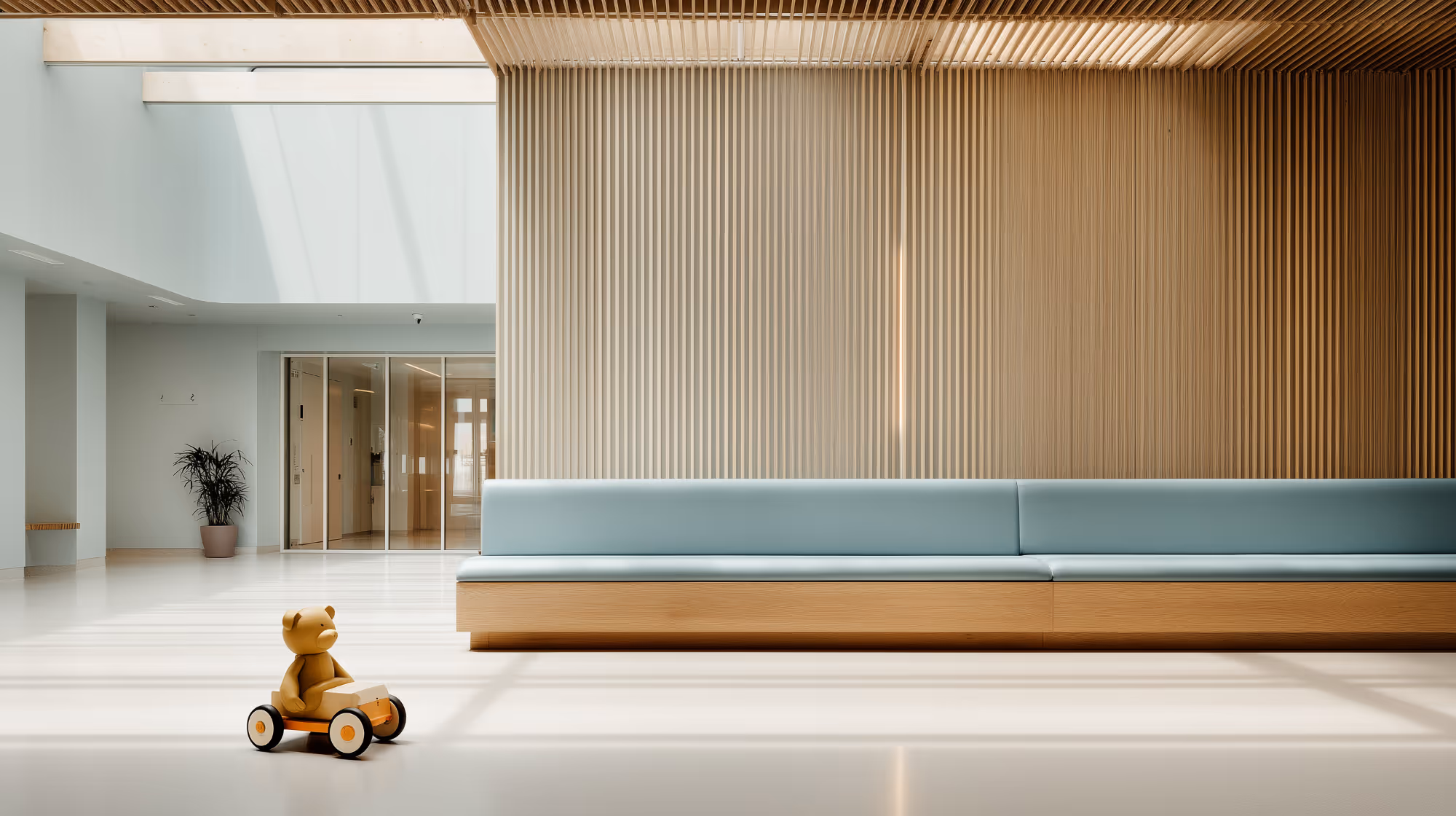 Minimalist interior with teddy bear on wooden toy car near blue couch