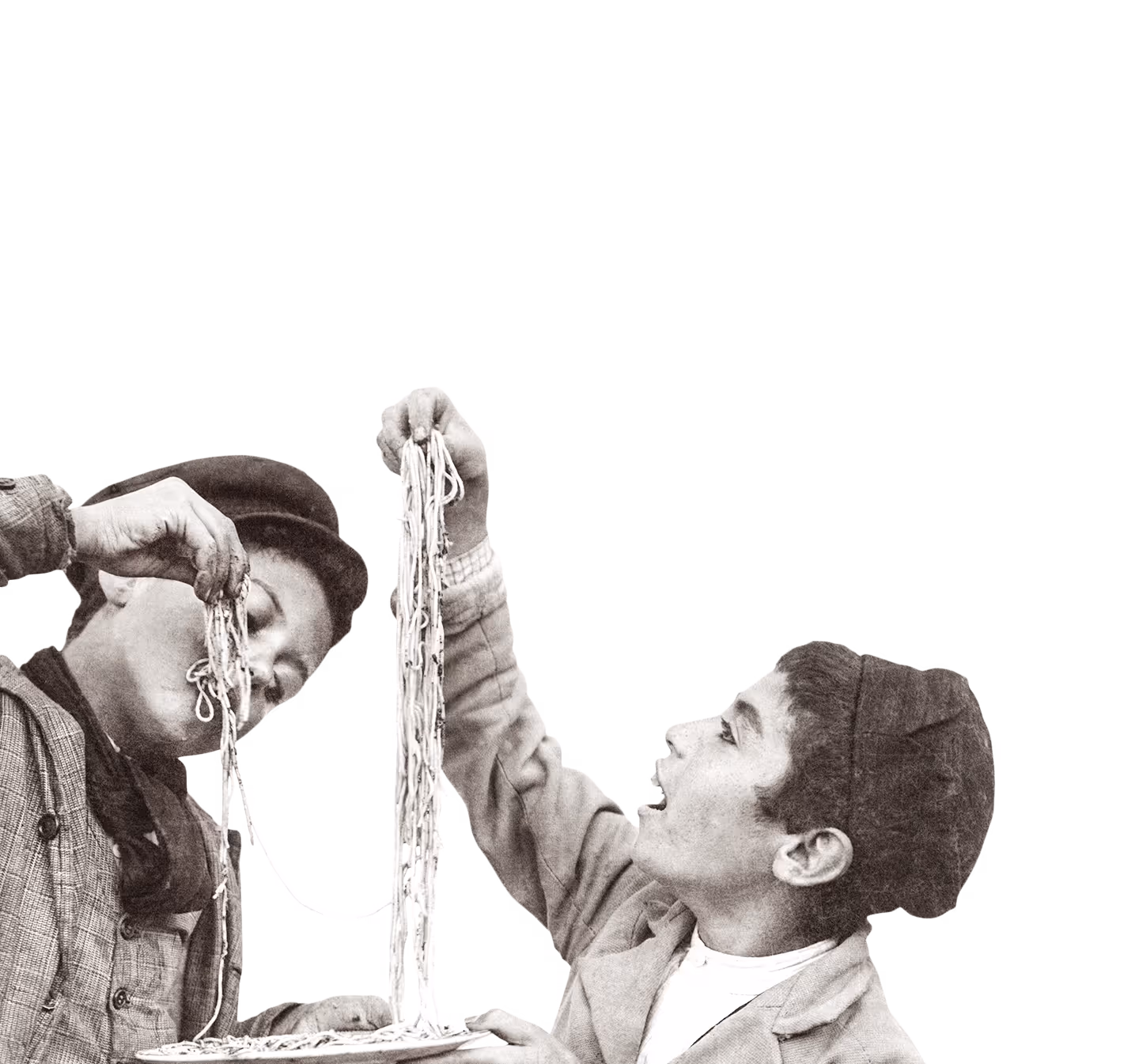 Zwei Jungen essen lachend lange Spaghetti, einer hält die Nudeln hoch.