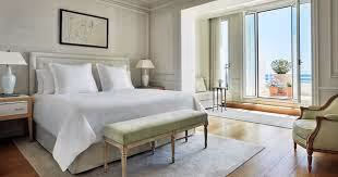 A bed with a bench in a roomDescription automatically generated