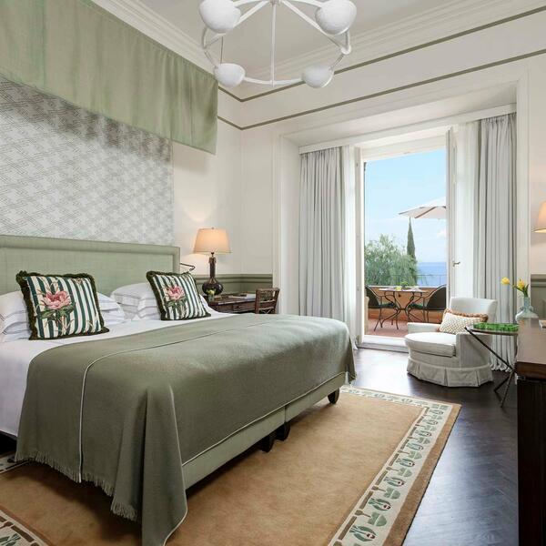 A bedroom with a bed and a deskDescription automatically generated