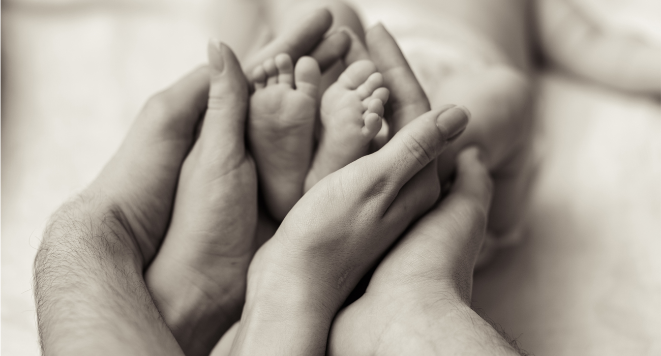 Parents holding their new born baby's feet