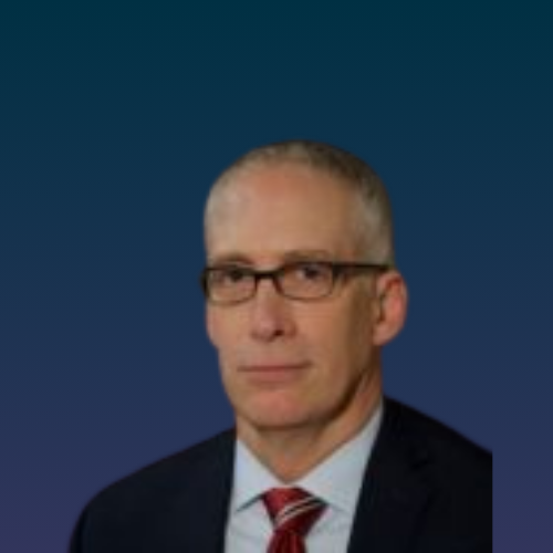 Headshot of a male in glasses with a dark suit coat with white dress shirt and red and white striped tie. 