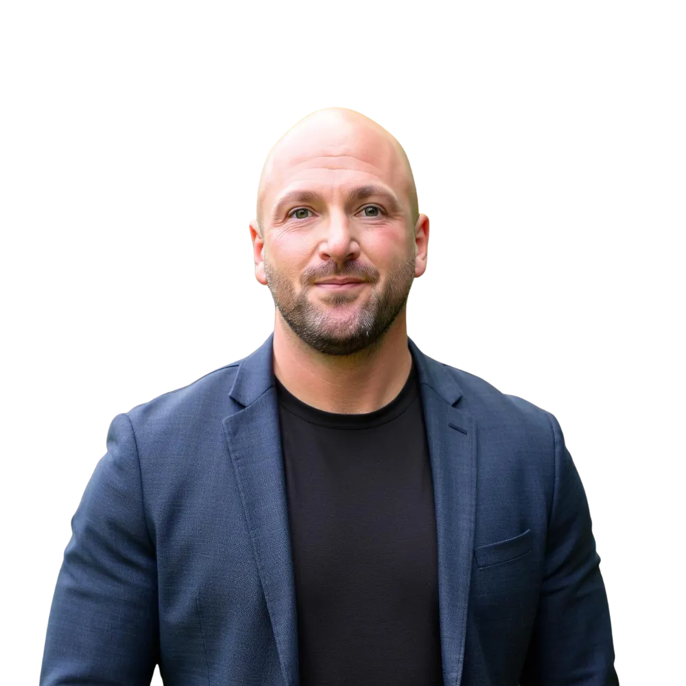 Headshot of a male in a blue suit coat and dark black shirt.