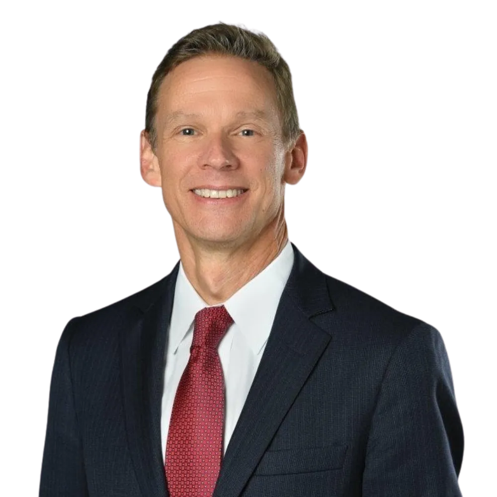 Headshot of a male in a dark suit with white dress shirt and red tie. 