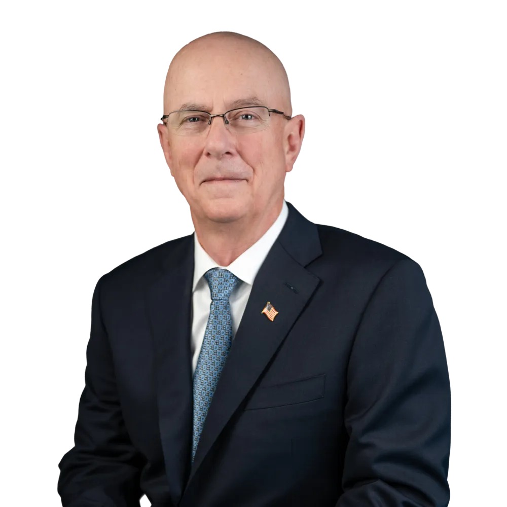 Headshot of a man with glasses in a suit. 