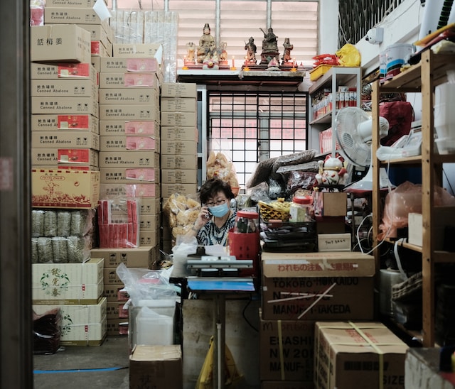 mujer llamando por teléfono en un almacén lleno de cajas