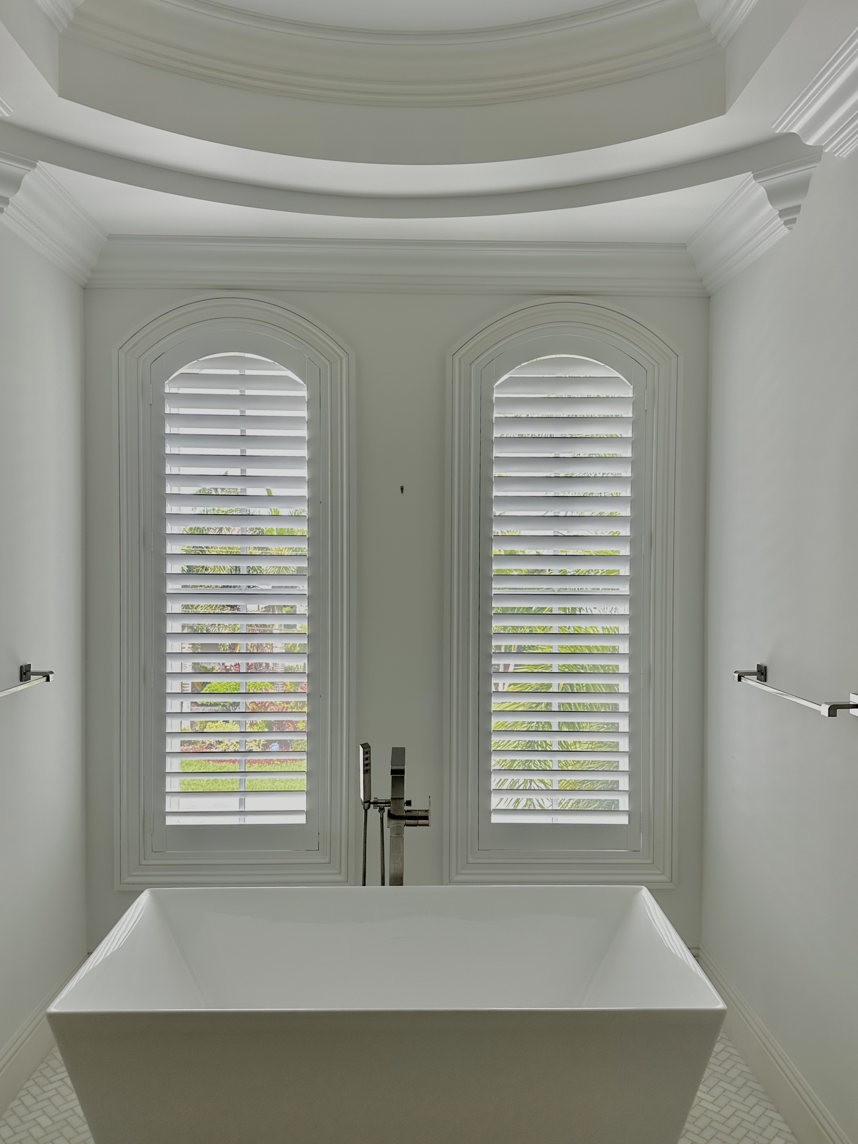 Poly plantation shutters on arched bathroom windows by RS Shutter Manufacturing