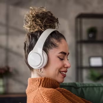 a woman wearing a pair of white wireless headphones